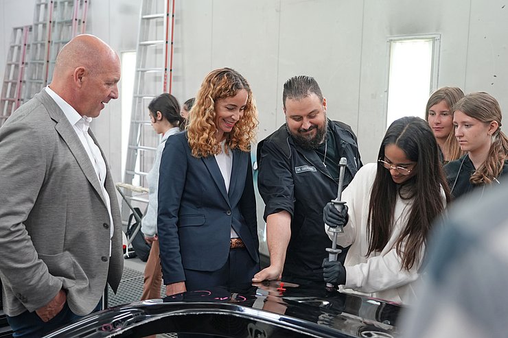 © Land Tirol/Reiter Mehrere Menschen begutachten ein Karosserieteil.