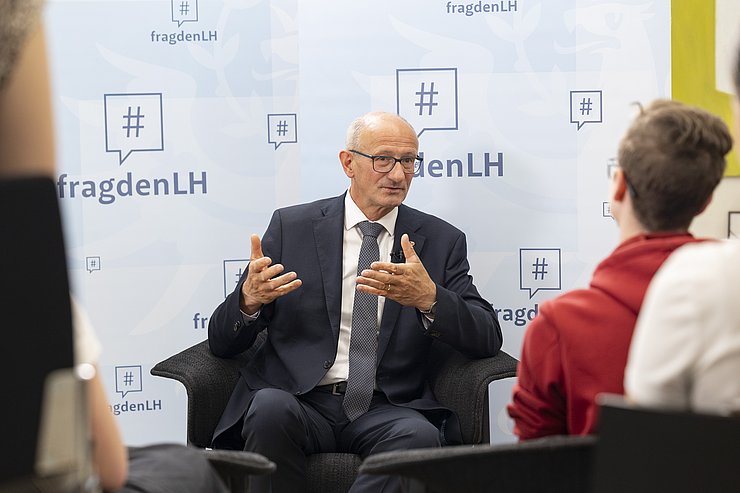 © Land Tirol/Die Fotografen LH Anton Mattle von vorne, wie er den SchülerInnen eine Frage beantwortet.