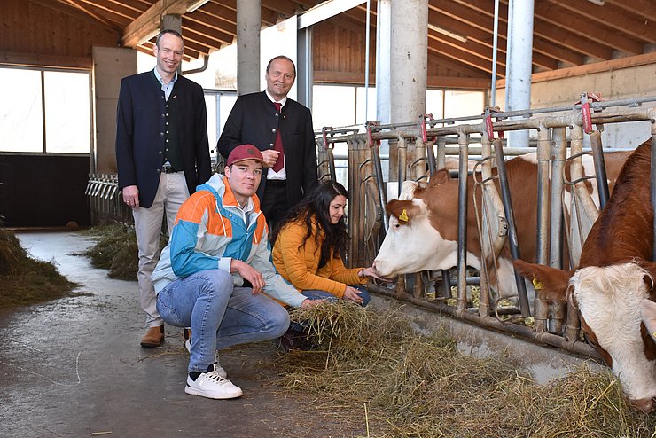 Studentinnen und Studenten in einem Kuhstall.