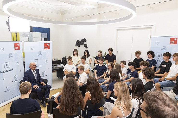 Ein Mann spricht zu mehreren Schülerinnen und Schülern.