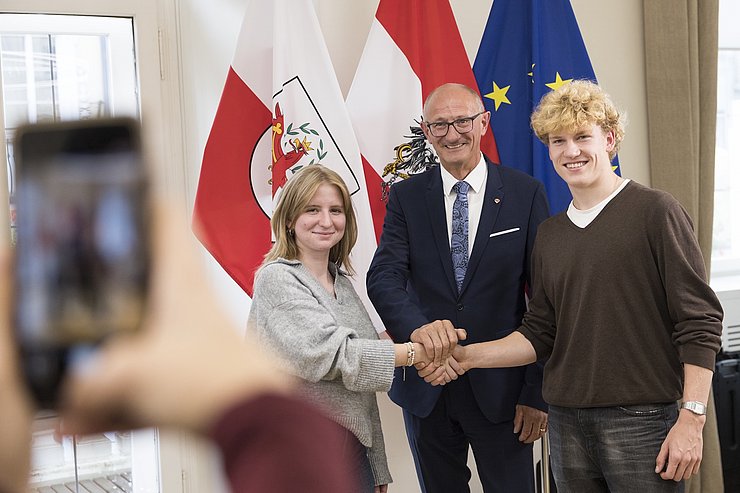 Drei Menschen halten ihre Hände im Zeichen der Verbundenheit zusammen.