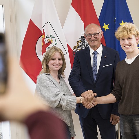 Drei Menschen halten ihre Hände im Zeichen der Verbundenheit zusammen.