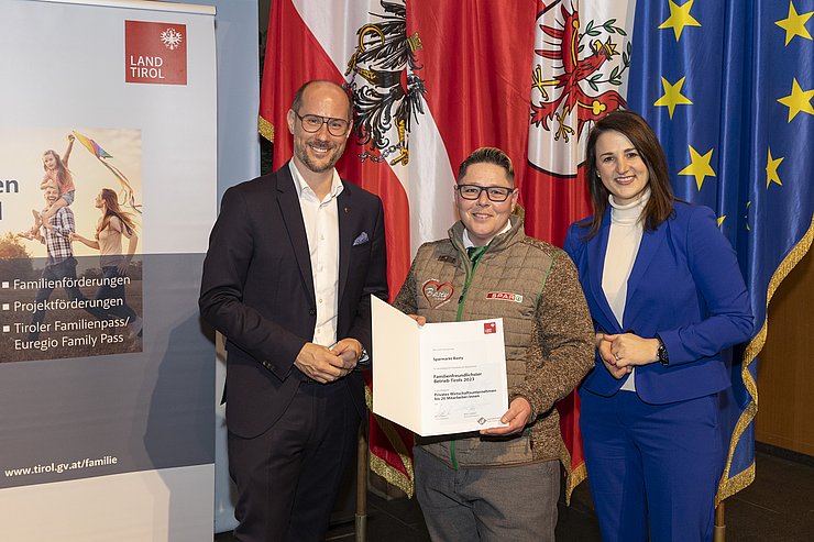 drei Personen mit Urkunde