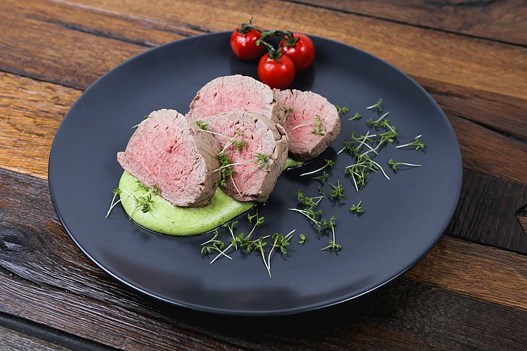 Teller mit pochierten Kalbsstücken; Fleischstücke sind innen zart rosa 