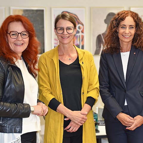 Gruppenfoto im Büro der LRin vor Schreibtisch und Bilderwand