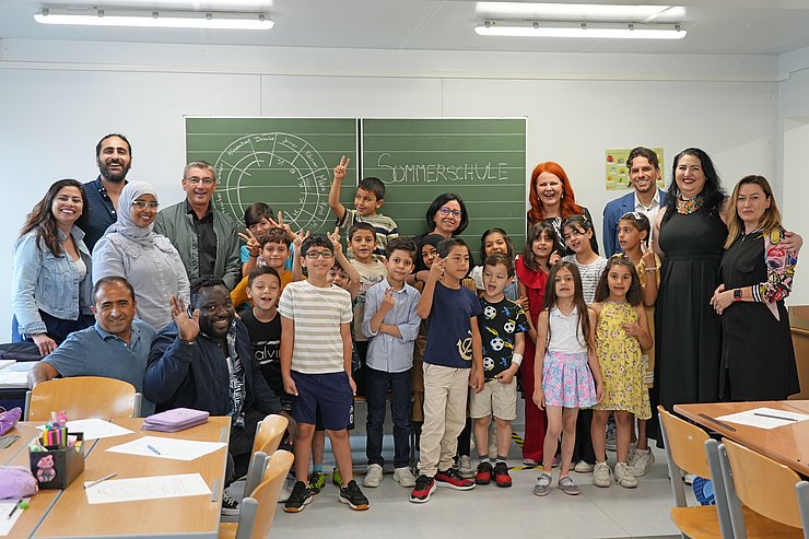 Eine Gruppe von Kindern und Erwachsenen stehen beisammen.