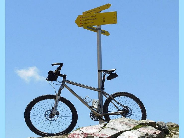 © Land Tirol - tiris Radl lehnt an Wegweiser