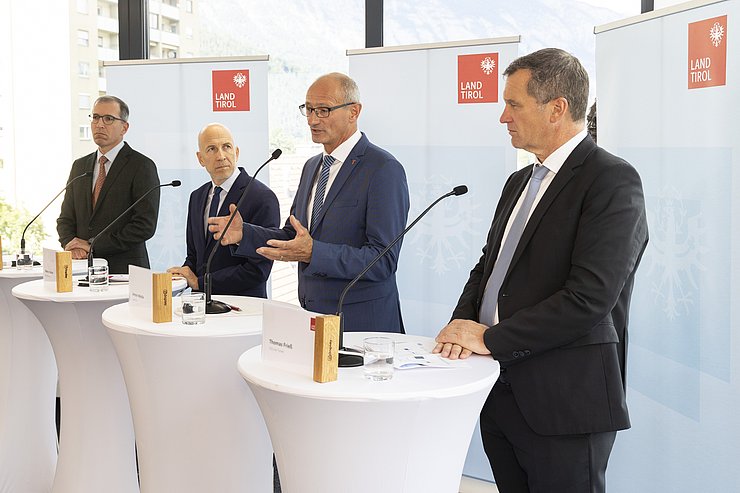 © Land Tirol/Die Fotografen Die vier Personen nebeneinander an den Rednerpulten stehend
