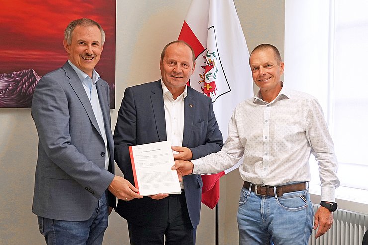 Drei Menschen posieren für ein Gruppenbild.