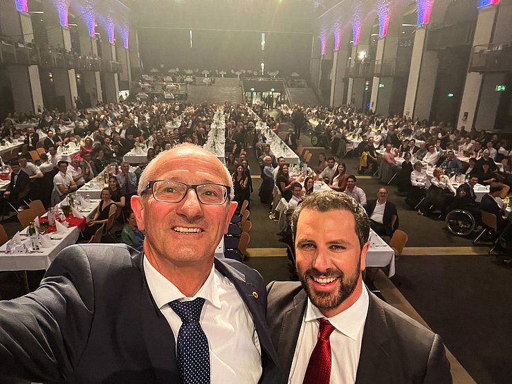Landeshauptmann Anton Mattle und sein Stellvertreter Georg Dornauer machen ein Foto von sich. Im Hintergrund ist der Saal mit Menschen im Congress Innsbruck zu sehen.