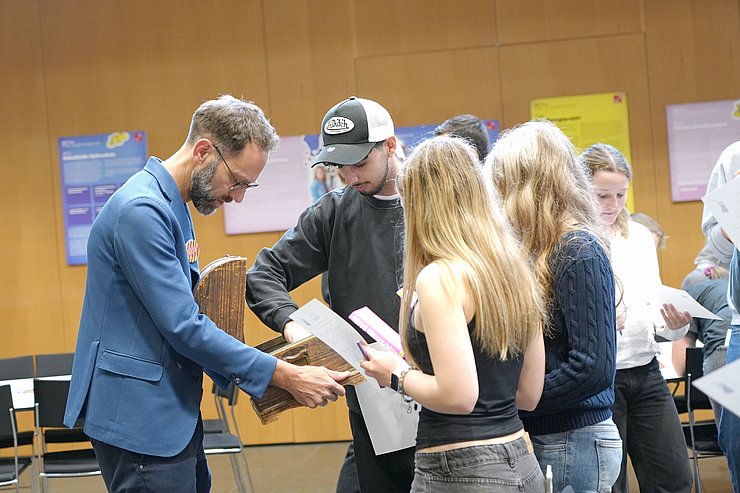 Jugendliche nehmen Zettel aus Box