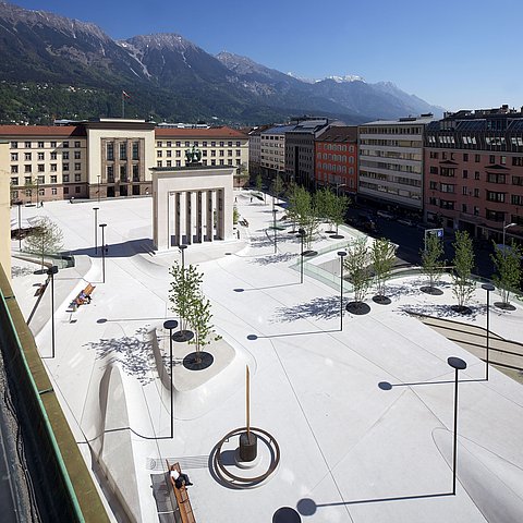 Der neugestaltete Landhausplatz mit Bäumen und Ruhebänken.