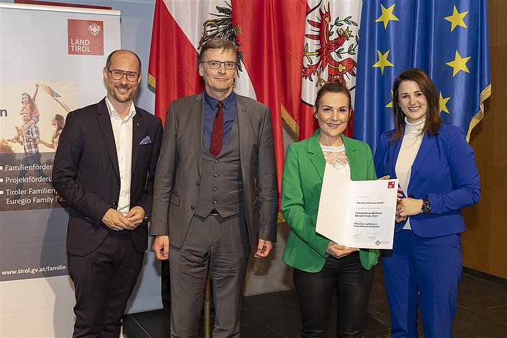 vier Personen mit Urkunde