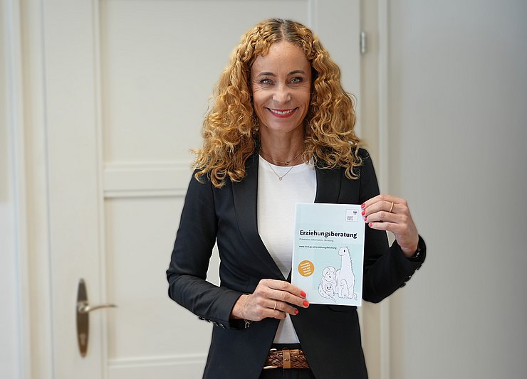 © Land Tirol/Dorfmann LRin hält Folder der Erziehungsberatung