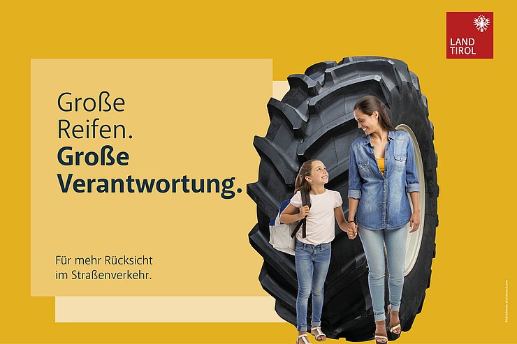 Mutter mit Kind vor einem Traktorreifen