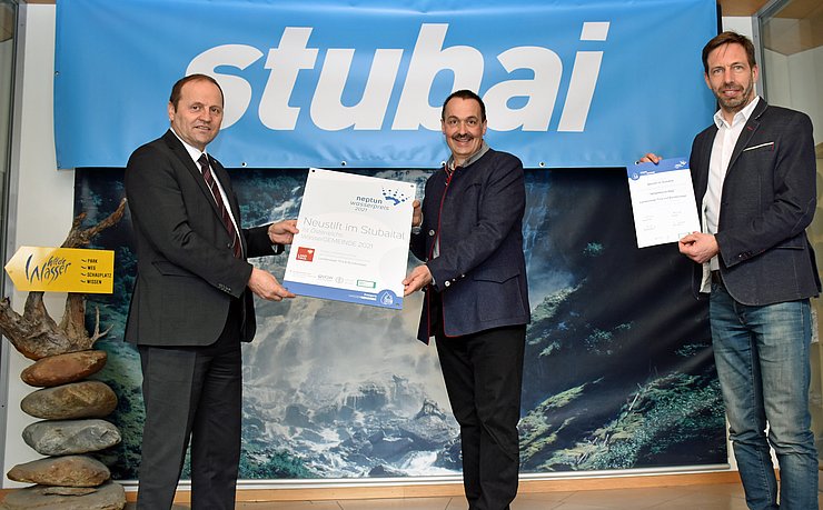 © Land Tirol/Entstrasser-Müller Der WildeWasserWeg in Neustift im Stubaital entschied Landes- und Bundeswertung für sich und holte sich den Neptun Wasserpreis 2021: LHStv Josef Geisler bei der Übergabe der Auszeichnung an Vizbgm Andreas Gleirscher und TVB-Obmann Adrian Siller (von rechts).