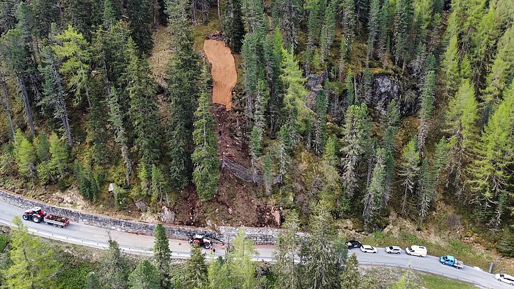 Luftaufnahme Straße durch den Wald; Böschung ist teilweise auf Straße gerutscht