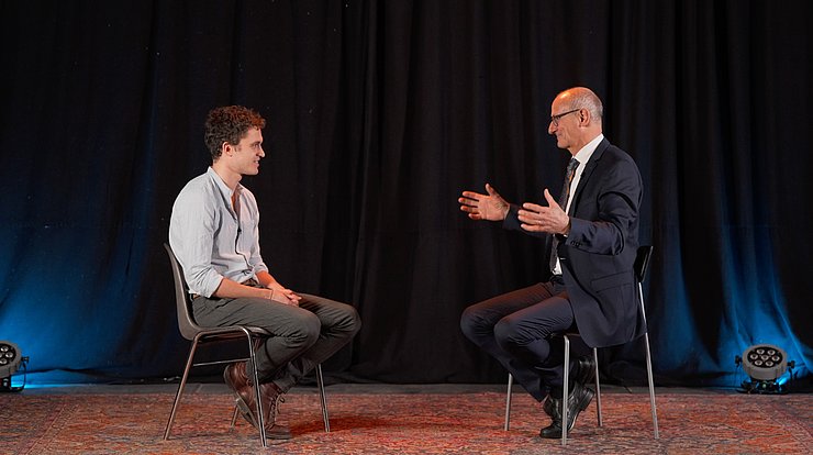 © Land Tirol Bühne mit zwei Stühlen auf denen LH Mattle und Kaschka sitzen und reden