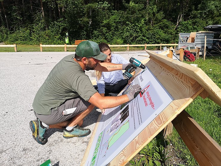Mann und Frau arbeiten an Holztafel
