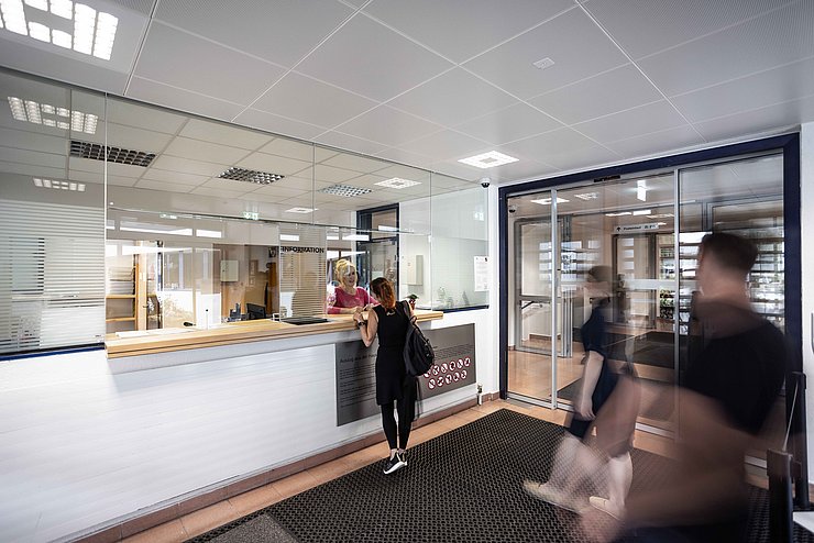 Mehrere Menschen befinden sich in einer Behörde.