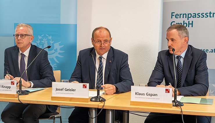 © Land Pölzl/Rauch Foto bei Pressekonferenz; drei Männer in Anzügen sitzend; vor ihnen Mikrofone