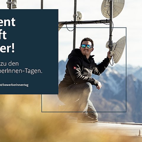 ein Mann kniet vor einem Sendemasten.