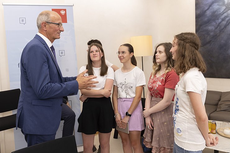 Anton Mattle redet mit vier SchülerInnen.