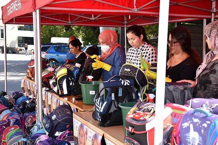 © Land Tirol/Dorfmann Stand, an dem Schultaschen von HelferInnen gereinigt werden