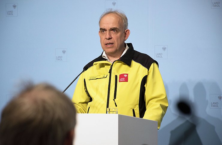 Rizzoli mit gelber Jacke redend