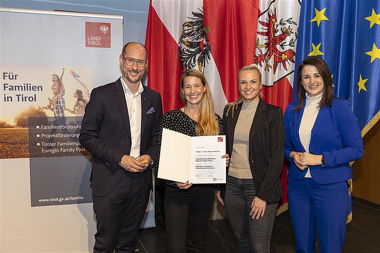 vier Personen mit Urkunde