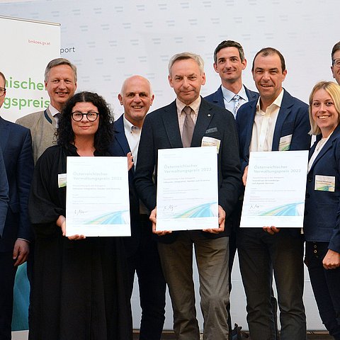 Gruppenfotos mit den Projektteams - die drei Personen in der Mitte halten jeweils eine Urkunde mit der Auszaichnung in Händen