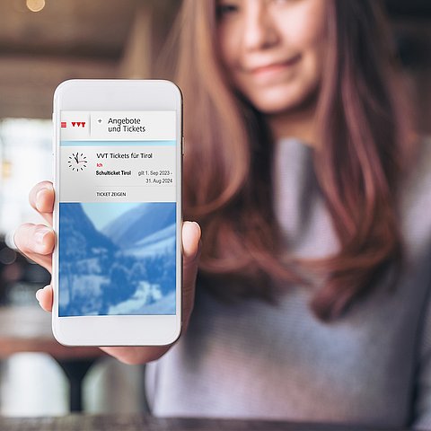 Frau hält Smartphone in die Kamera - digitales Öffi-Ticket