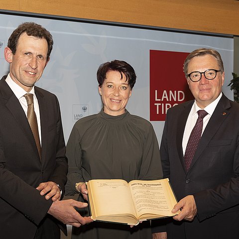 v.li.: Christoph Grabenwarter (Präsident des Österreichischen Verfassungsgerichtshofes), Landtagspräsidentin Sonja Ledl-Rossmann und LH Günther Platter mit dem Landesgesetz- und Verordnungsblatt, in dem die Landesordnung vor 100 Jahren verlautbart wurde. 