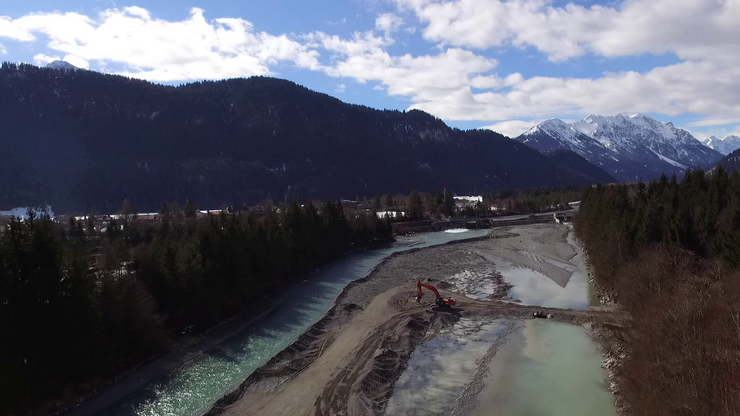 Schotterentnahme im Lech. Im Hintergrund die Wehranlage Höfen / Ehenbichl. (Blickrichtung flussaufwärts)