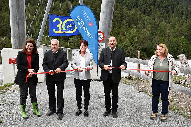 © Land Tirol/Pölzl Personen durchschneiden rotes Band vor Brücke