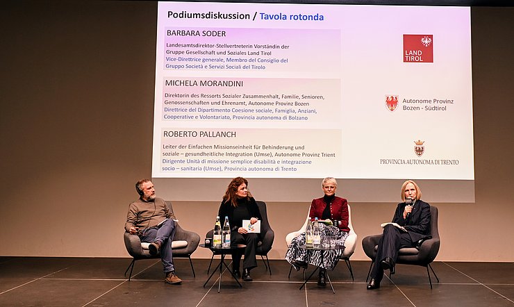 Personen sitzen am Podium