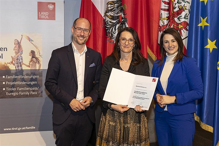 drei Personen mit Urkunde