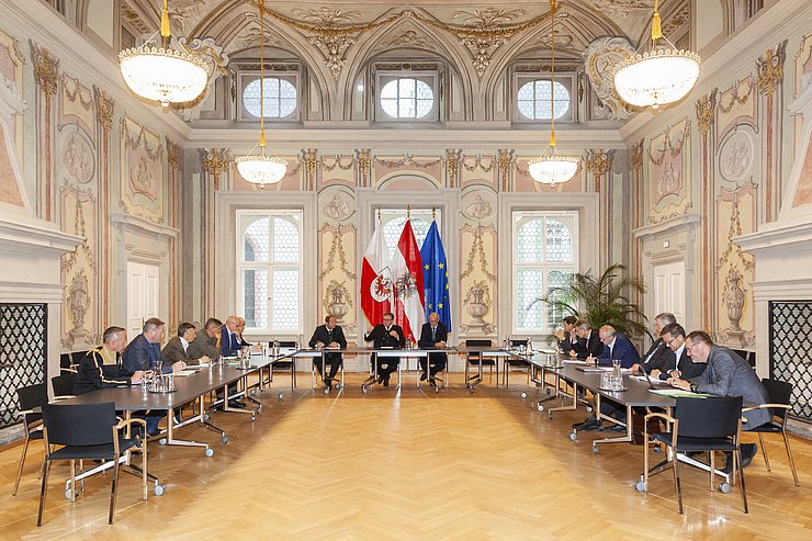 Die TeilnehmerInnen im Saal an Tischen sitzend in U-Form aufgestellt.