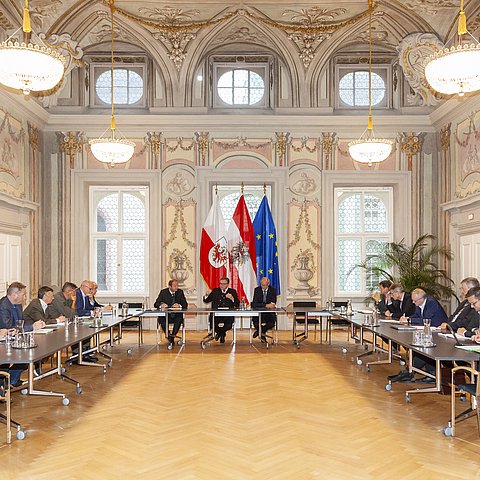 Die TeilnehmerInnen im Saal an Tischen sitzend in U-Form aufgestellt.