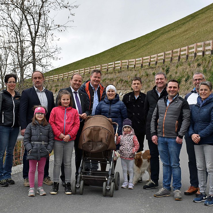 © Land Tirol BewohnerInnen von Oberleibnig sowie LHStv Josef Geisler (5. v. li.) und Bgm Franz Gollner (2. v. li.) stehen in einer Gruppe auf der sanierten Straße.
