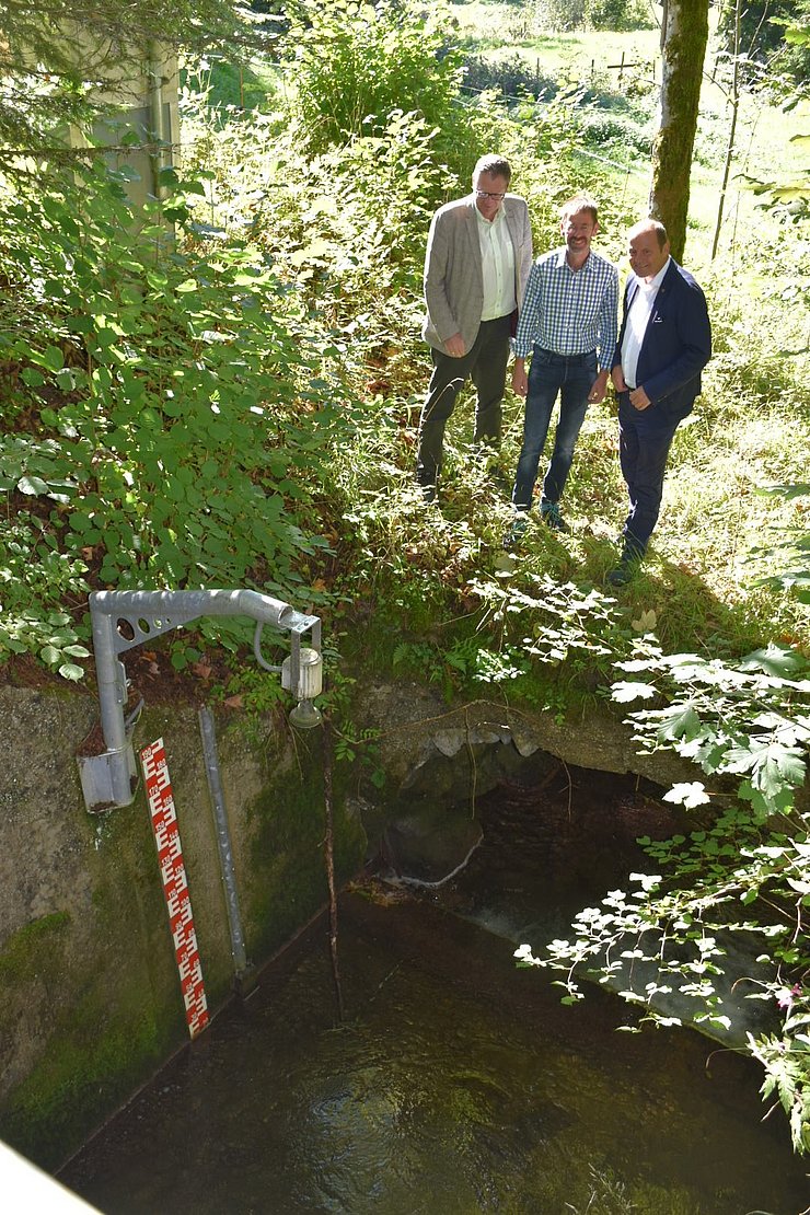 Alois Mauracher, Klaus Niedertscheider und Josef Geisler stehen bei der Messstelle am Walchentaler Bach