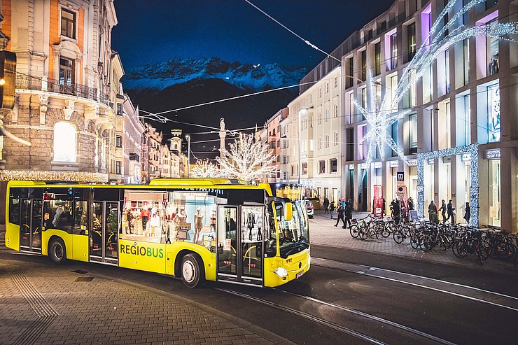 © Verkehrsverbund Tirol Fahrender Bus auf der Anichstraße vor dem Kaufhaus Tyrol bei Nacht