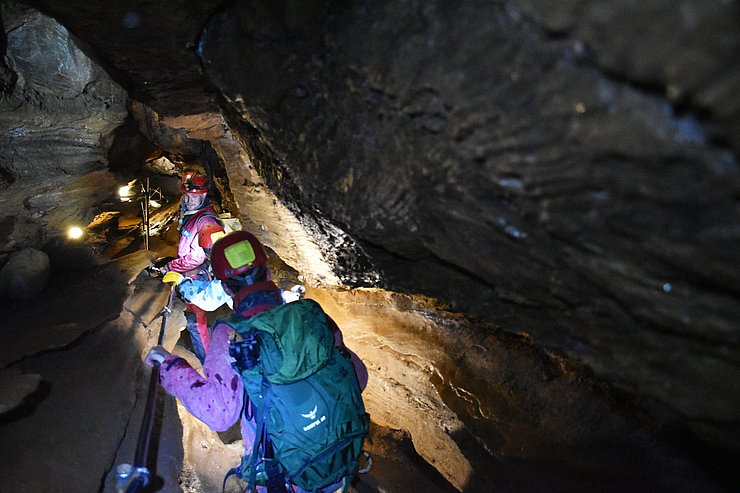 LRin Mair durch engen Höhlengang gehend