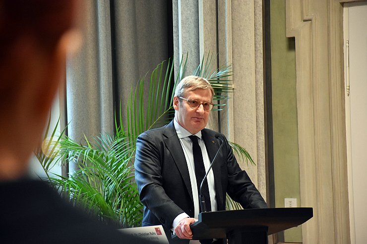 Mann steht an Rednerpult