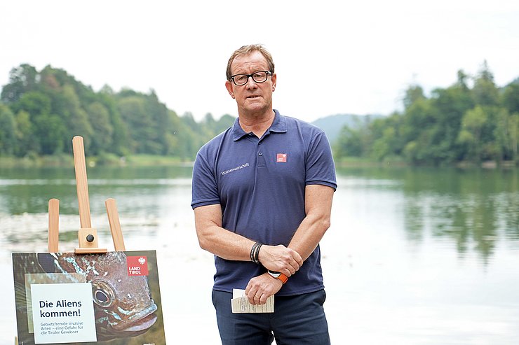 © Land Tirol/Hörmann Ein anderer Mann steht auf einem Steg am Rande eines Sees.