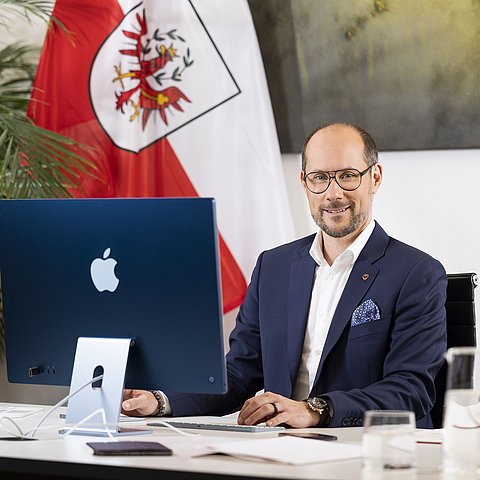 LR Mario Gerber in seinem Büro vor einem Computerbildschirm.
