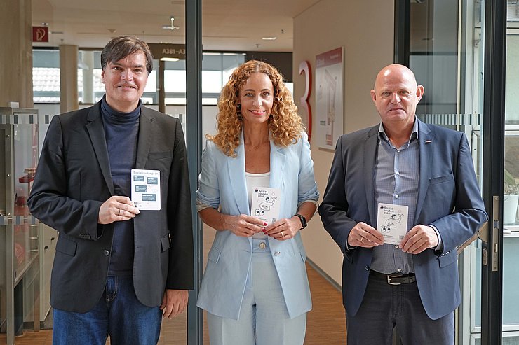 © Land Tirol/Reiter Personen stehen nebeneinander, halten Flyer