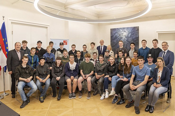 Mehrere Menschen posieren für ein gemeinsames Gruppenbild.