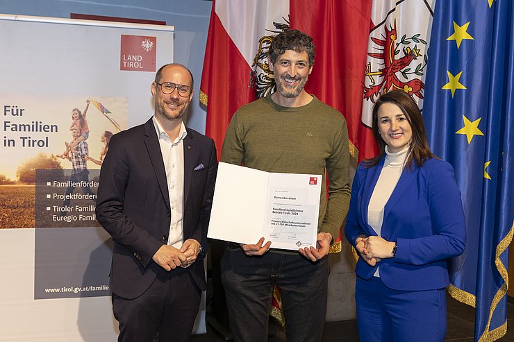 drei Personen mit Urkunde