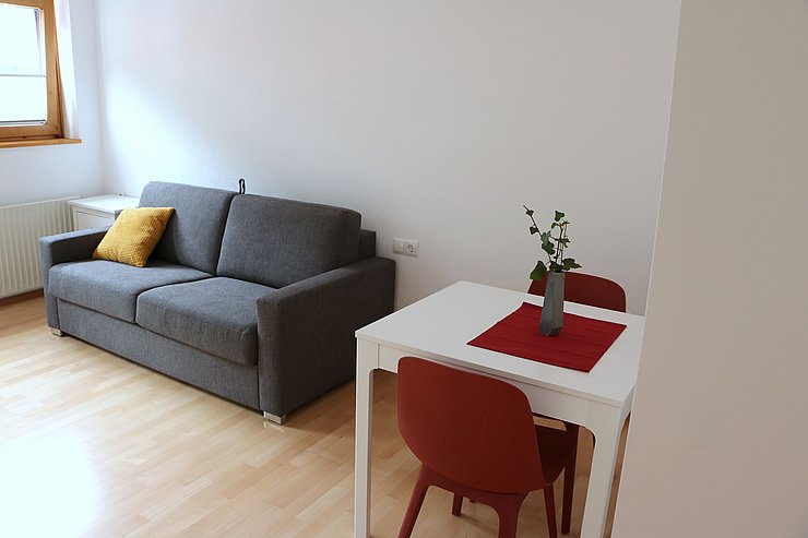 Bild von Wohnzimmer mit Tisch im Frauenhaus. 